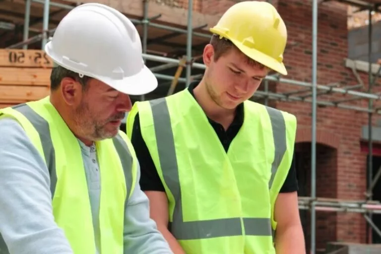 Engineering students in high-visibility vests working on a construction project outdoors.